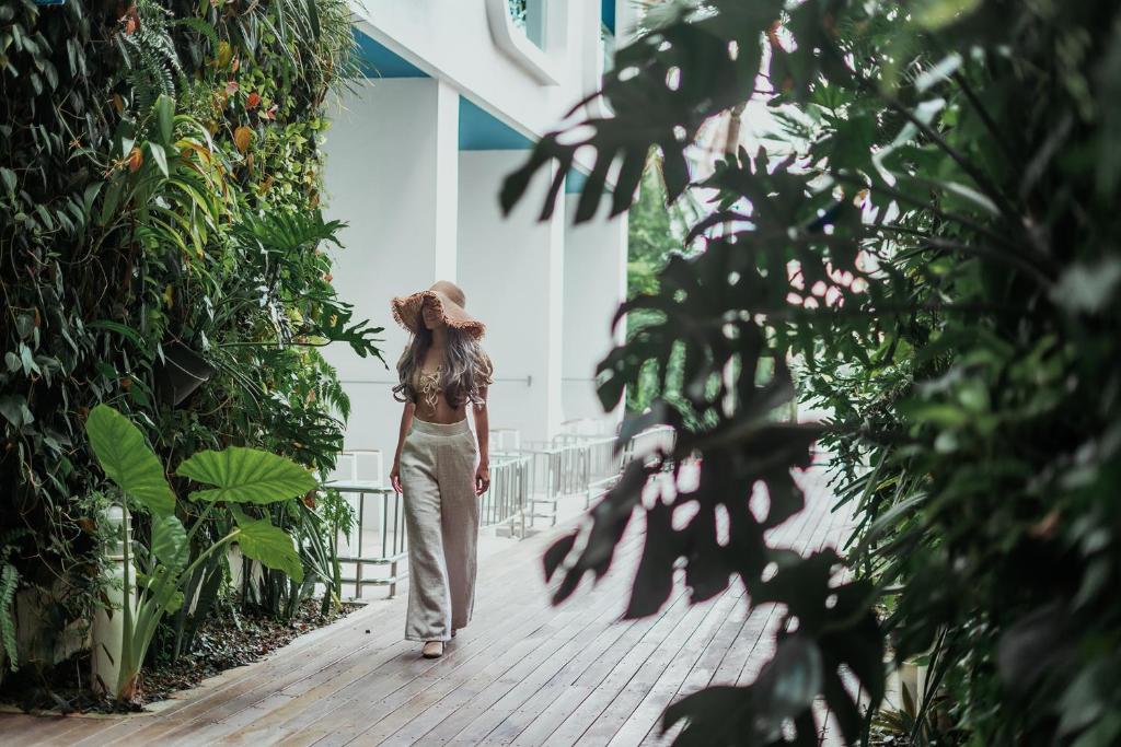 Sieviete pastaigājas pa zaļo oāzi Sugar Marina Nautical viesnīcā.