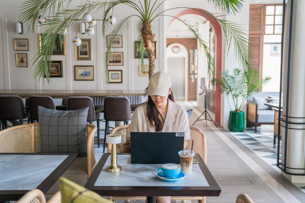 Mūsdienīgs interjers Sugar Marina Nautical ar viesi, kas strādā pie datora.