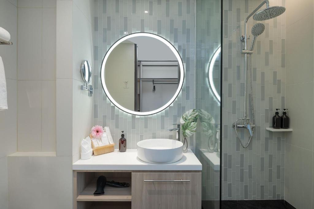Mūsdienīgs vannas istabas dizains hotelī Jono X Phuket Karon, iekļaujot dušu un elegantu izlietni.