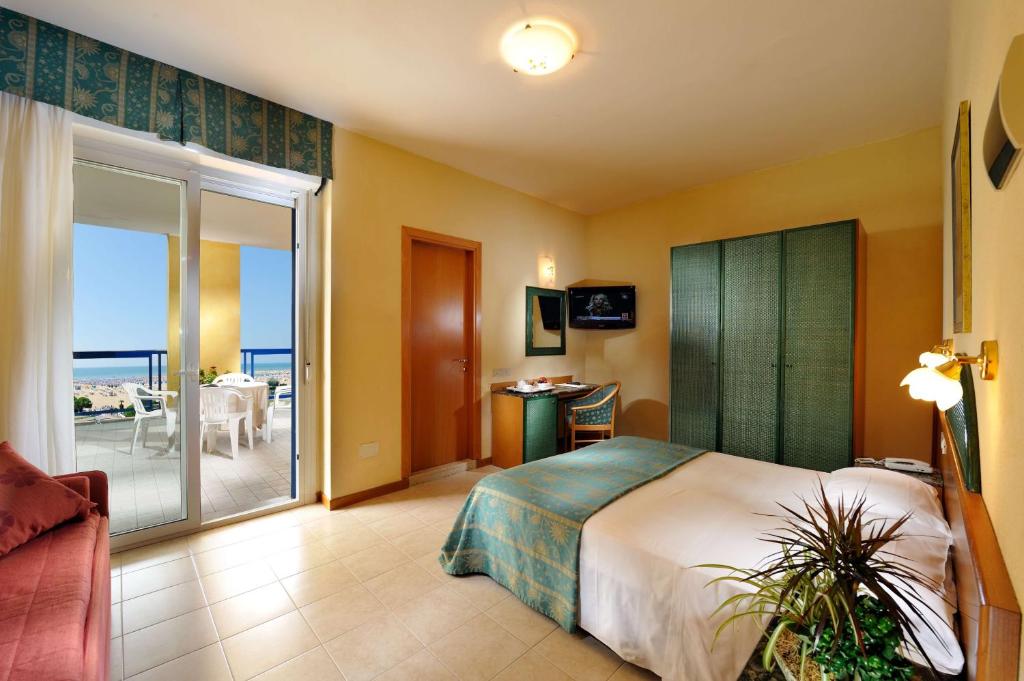 Mūsdienīgs viesnīcas numurs ar balkonu un skatu uz jūru, iekārtots ar divguļamo gultu, galdu un televizoru. Numurā ir arī dabiski elementi, piemēram, augu dekorācijas.