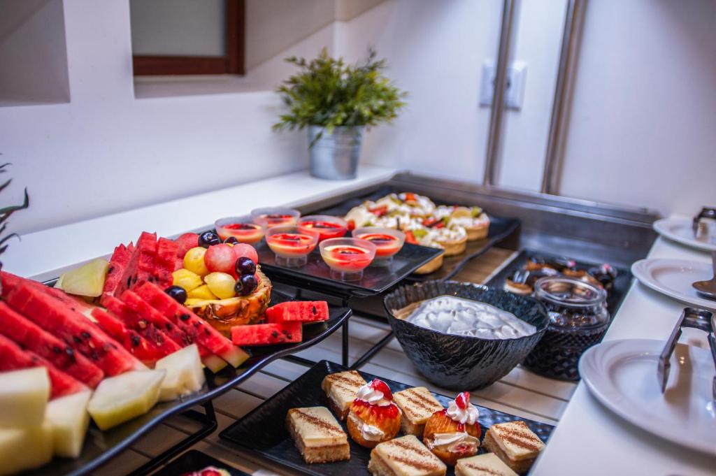 Bufete ar dažādiem augļiem, desertiem un saldējumu, kas izkārtoti uz galda. Krāsaini, svaigi ēdieni rada patīkamu atmosfēru.