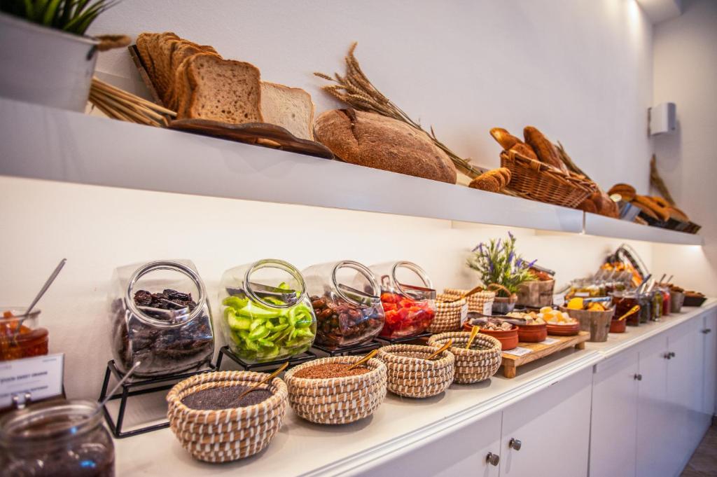 Bagātīgs brokastu bufete ar dažādām maizēm, augļiem un dārzeņiem, kas pasniegti glītās traukos un grozos. Ideāla izvēle veselīgām un garšīgām brokastīm.