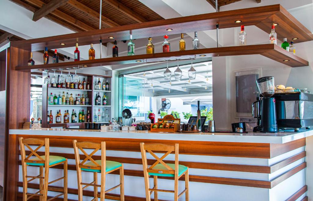 Mūsdienīgs bārs ar koka plauktiem, uz kuriem izvietoti alkohola dzērieni un glāzes, kā arī komfortablām koka krēslām ar zaļām sēdvietām. Interjers ir gaišs un elegants, radot patīkamu atmosfēru.
