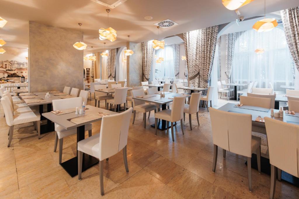 Moderns restorāns ar gaišu interjeru un elegantiem galdiem, apgaismots ar stilīgām lampām. Plašas logu ailes nodrošina dabīgu gaismu un komfortablu atmosfēru.
