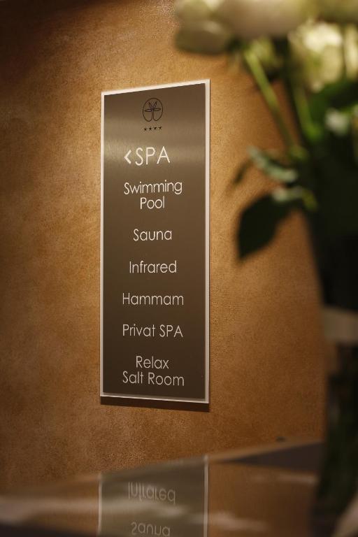 SPA zīme ar pakalpojumiem, tostarp peldbaseins, sauna, infrasarkanā terapija, hammam, privāts SPA un relaksācijas sāls istaba. Ideāla izvēle relaksācijai un atpūtai.