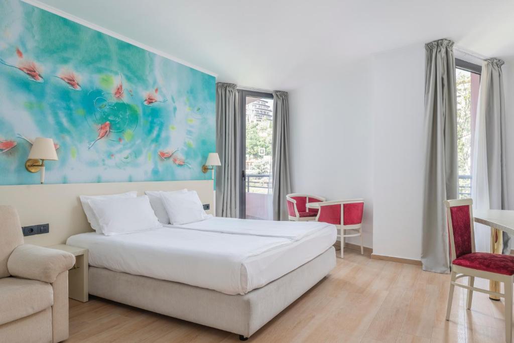 Mūsdienīgs viesnīcas numurs ar vieglu interjeru un krāsainu sienu gleznojumu. Numurā ir divguļamā gulta, dīvāns un galds ar krēsliem, kas rada patīkamu un mājīgu atmosfēru.