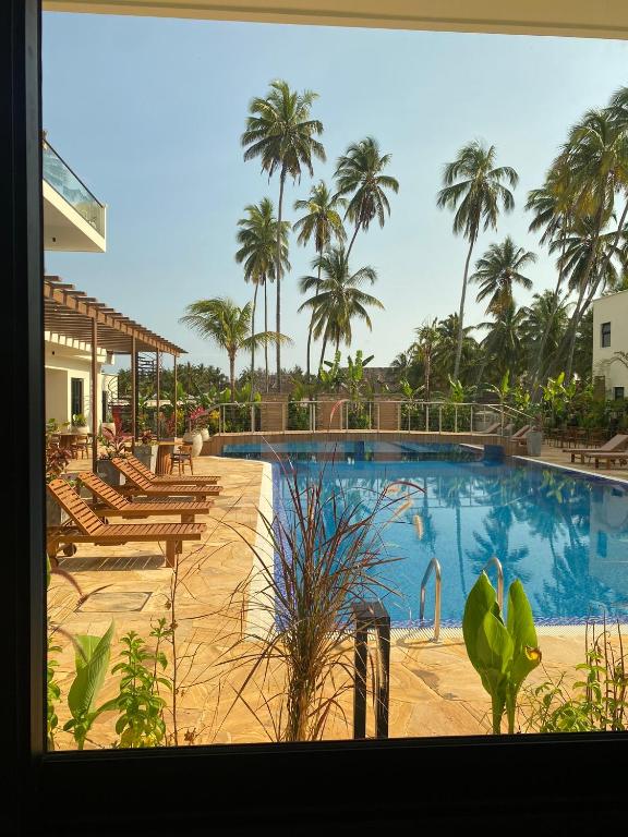 TOA Hotel & Spa baseins ar palmām un saules krēsliem