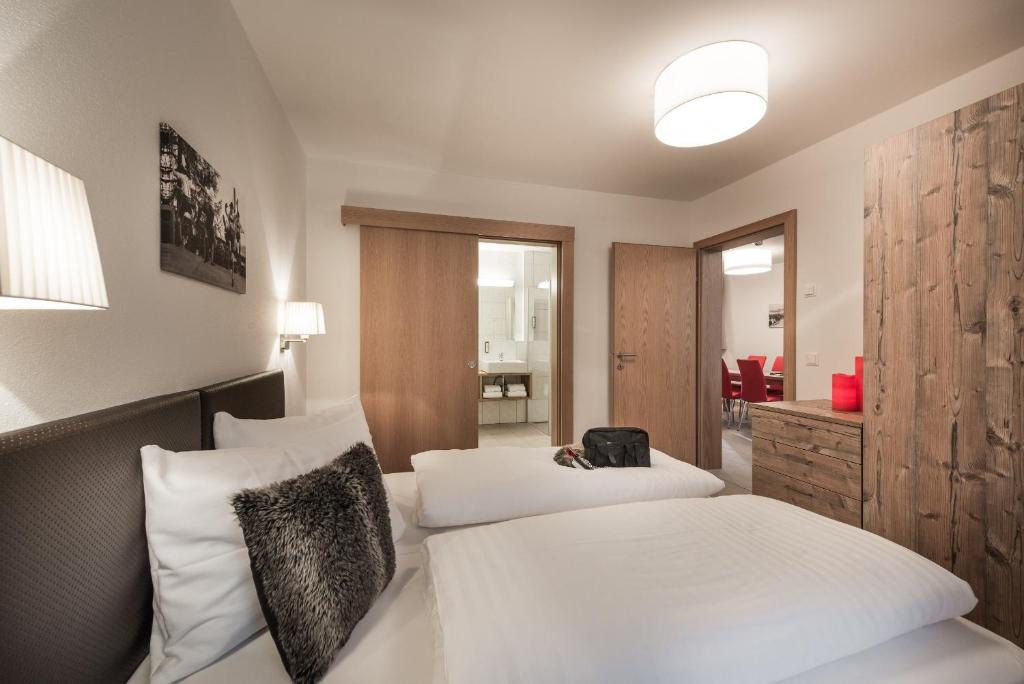 Mūsdienīgs viesnīcas numurs ar divām gultām, koka mēbelēm un piekļuvi vannas istabai. Interjerā ir siltas krāsas un mūsdienīgs apgaismojums.