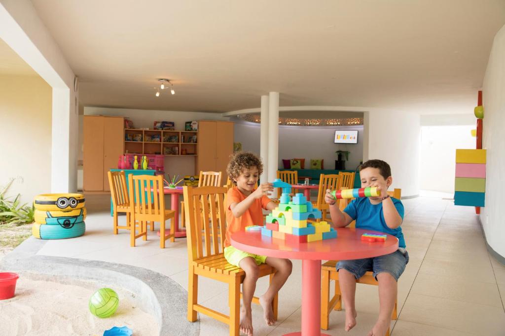 Bērni spēlējas ar krāsainām kluču spēlēm Tamassa Bel Ombre.