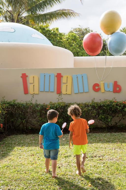 Bērni pie TamTam kluba ar konfektēm rokās, piekrastē.