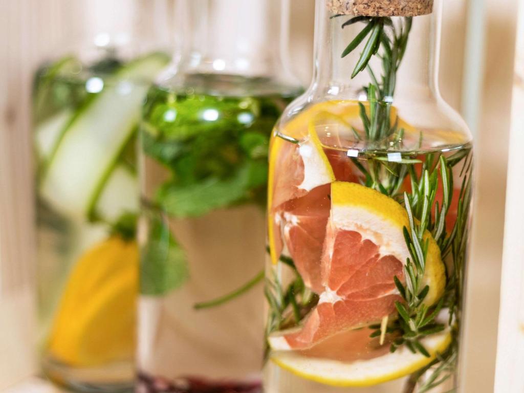 Stikla pudeles ar garšaugiem un citrusaugļu šķēlītēm, kas dekorētas ar rozmarīnu un citrons. Ideālas dzērienu pagatavošanai vai dekorēšanai.