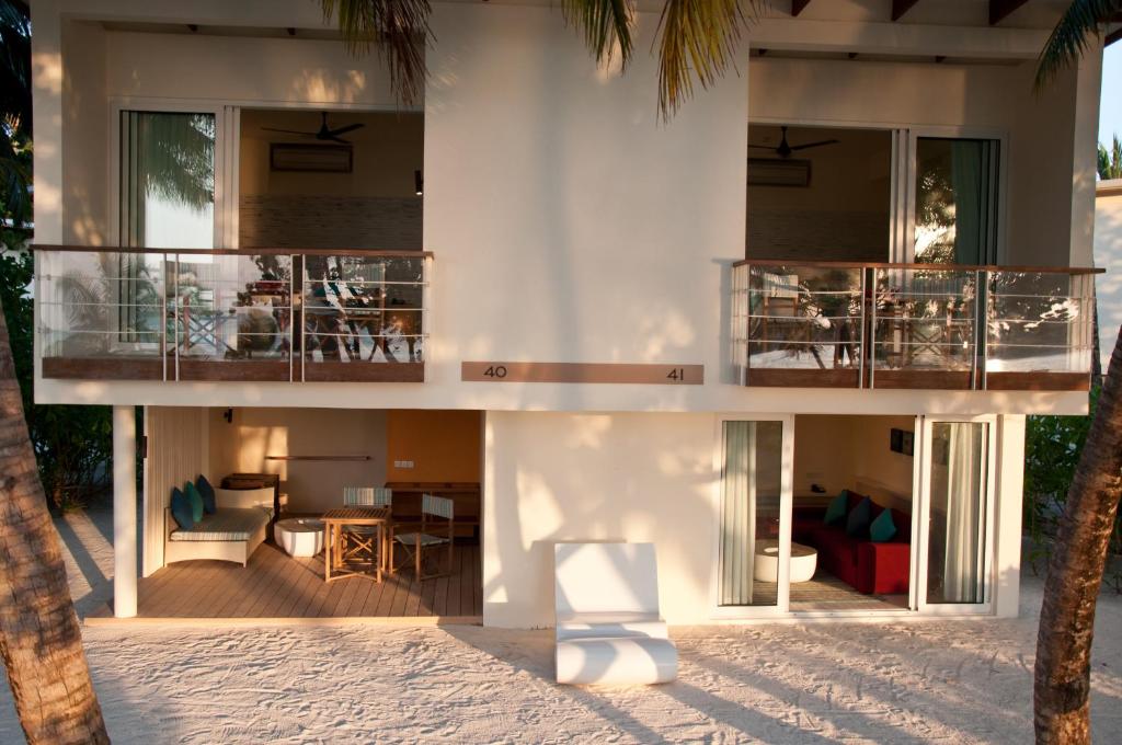 Divstāvu pludmales viesnīcas numuri ar balkoniem un mūsdienīgu interjeru, ieskauti palmās un smilšainā vidē. Ideāli piemēroti atpūtai pie jūras.