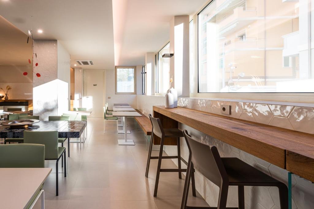 Moderns restorāns ar gaišām telpām un koka mēbelēm.