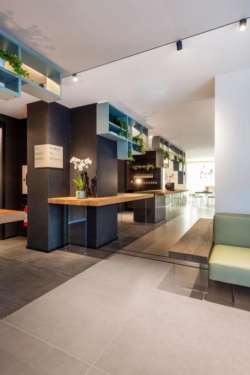 Moderns viesnīcas reģistratūras interjers ar koka un stikla akcentiem.