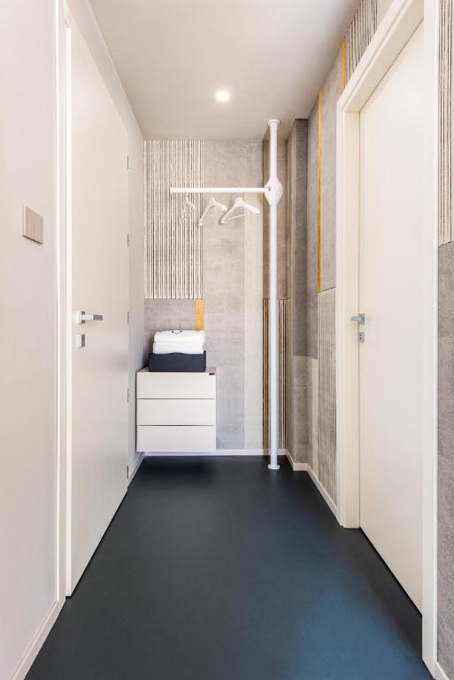 Mūsdienīgs viesnīcas koridors ar baltām durvīm un stilīgu dekori.