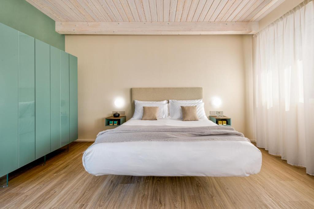 Moderns numurs ar gultu, koka grīdu un gaišām sienām.