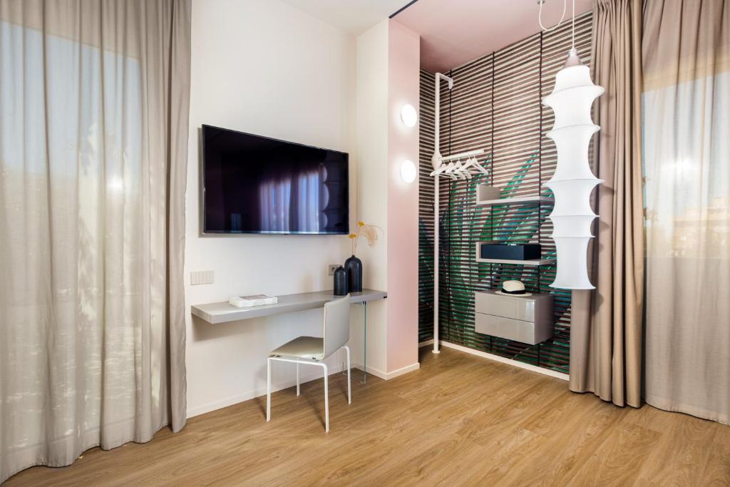 Modern hotel room with a desk, TV, and stylish decor.