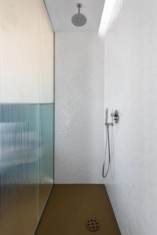 Modern shower with hexagonal tiles and a glass partition.