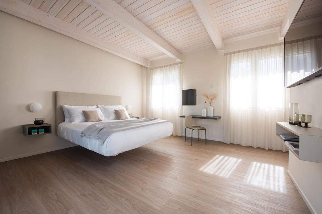 Mūsdienīga viesnīcas numura interjers ar gultu un lieliem logiem.