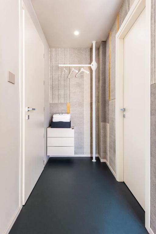 Gaisma un moderna ieeja ar skapīti un drēbju pakaramo.