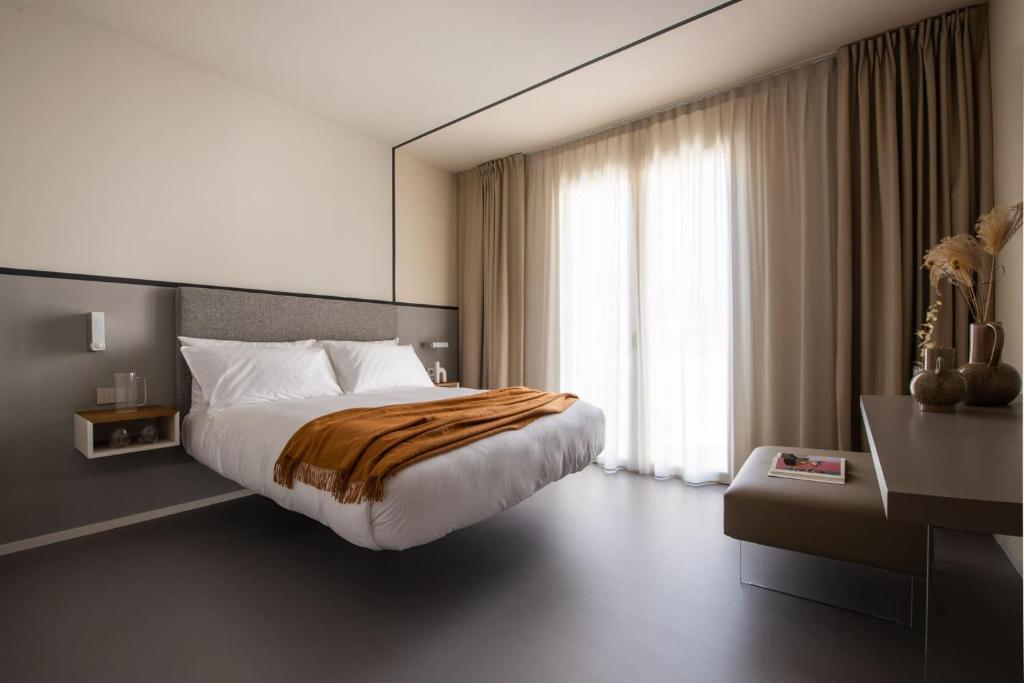 Moderns viesnīcas numurs ar gultu un dabiskiem apgaismojumiem.