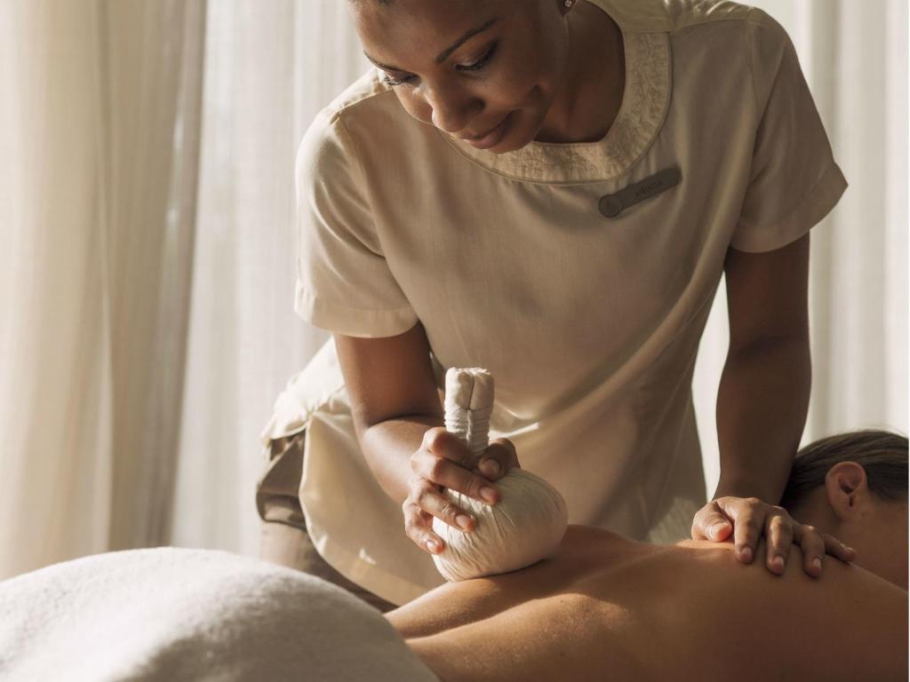 Masāža ar zāļu kompresēm Four Seasons Resort Seychelles spa centrā.