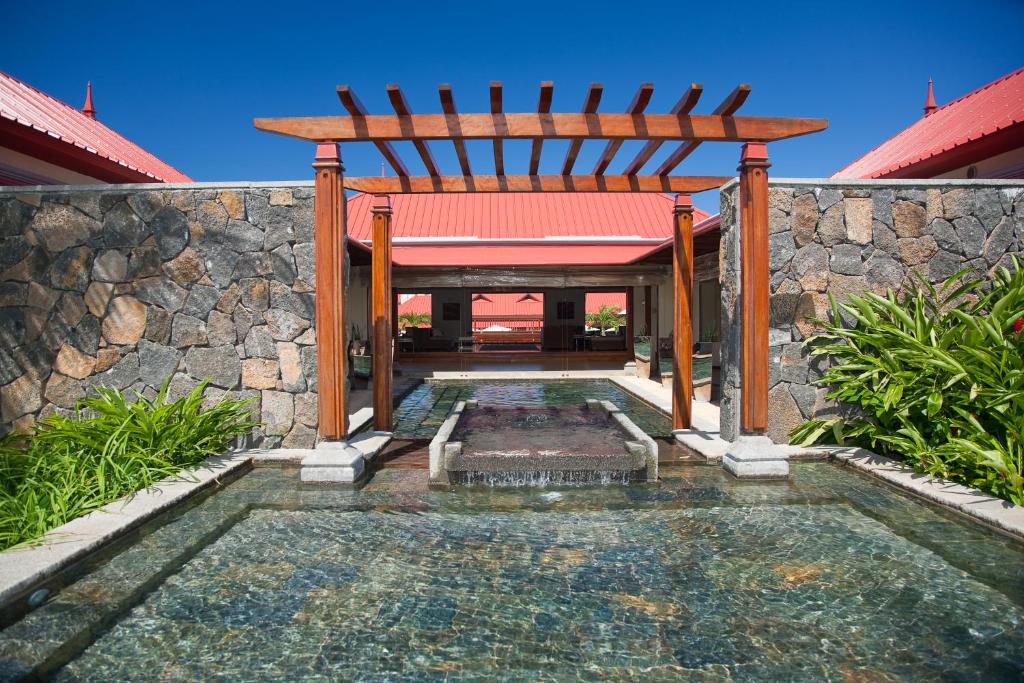 Ieiešana uz Tamassa Bel Ombre ar akmens sienām un ūdens elementiem.