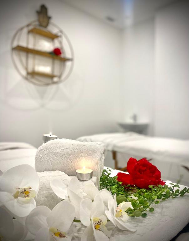 Spa procedūras telpa ar baltajiem dvieļiem, svecēm un ziediem, radot relaksējošu atmosfēru. Svaigi ziedi un svecītes pievieno estētiku un mieru.