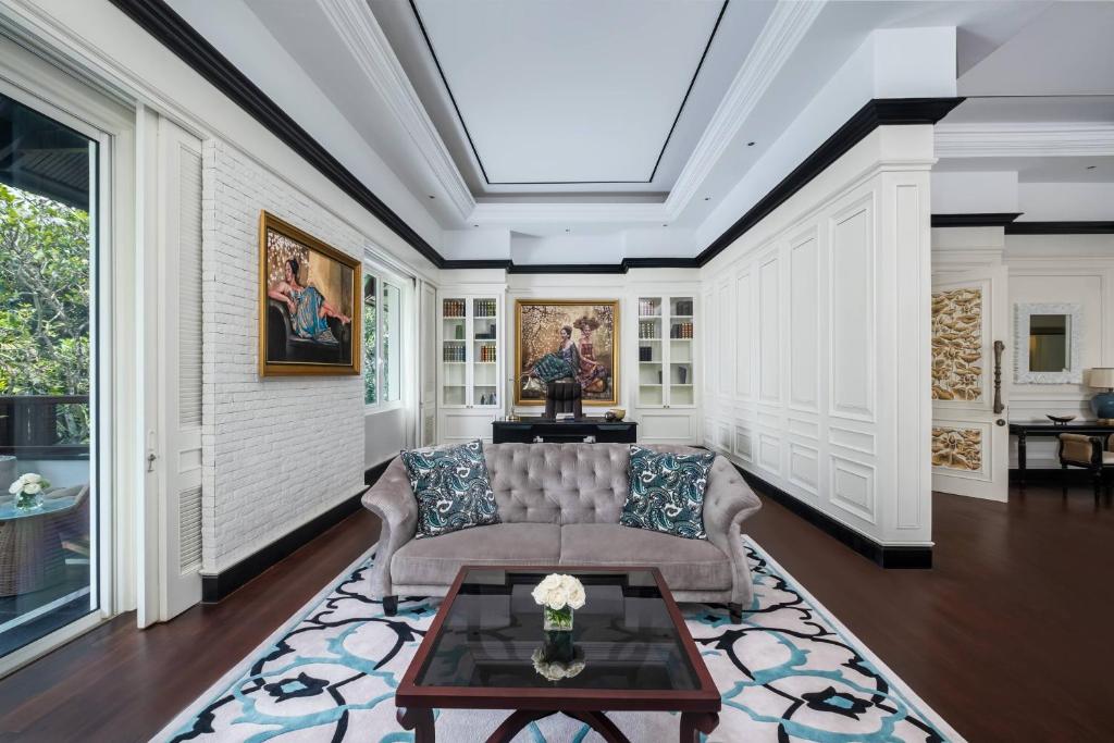 Mūsdienīgs viesistabas interjers ar elegantām gleznām, komfortablu dīvānu un stilīgu grīdas paklāju, kas rada mājīgu atmosfēru.