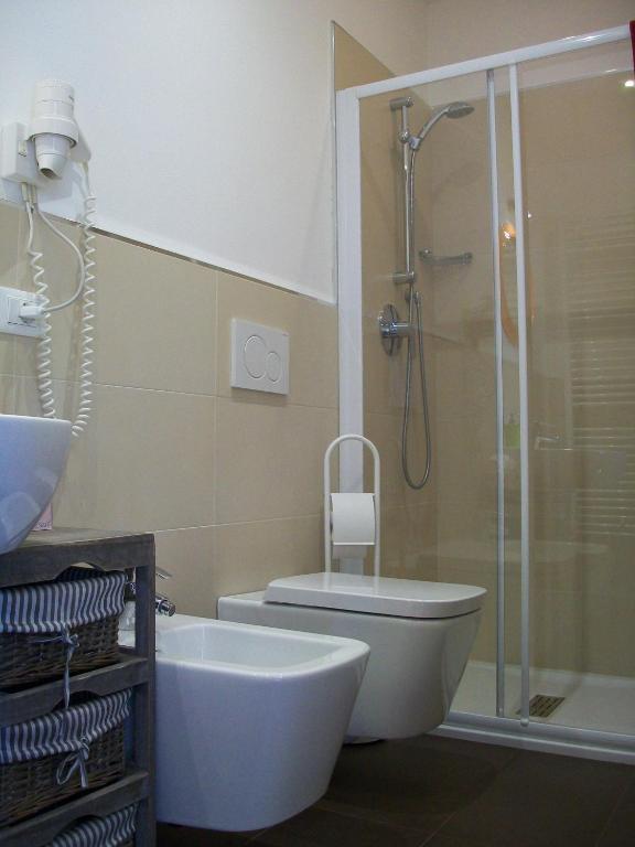 Mūsdienīgs vannas istabas interjers ar dušas kabīni, tualeti un izlietni. Telpa ir gaiša un funkcionāla, ar vienkāršām līnijām un stilīgu dizainu.