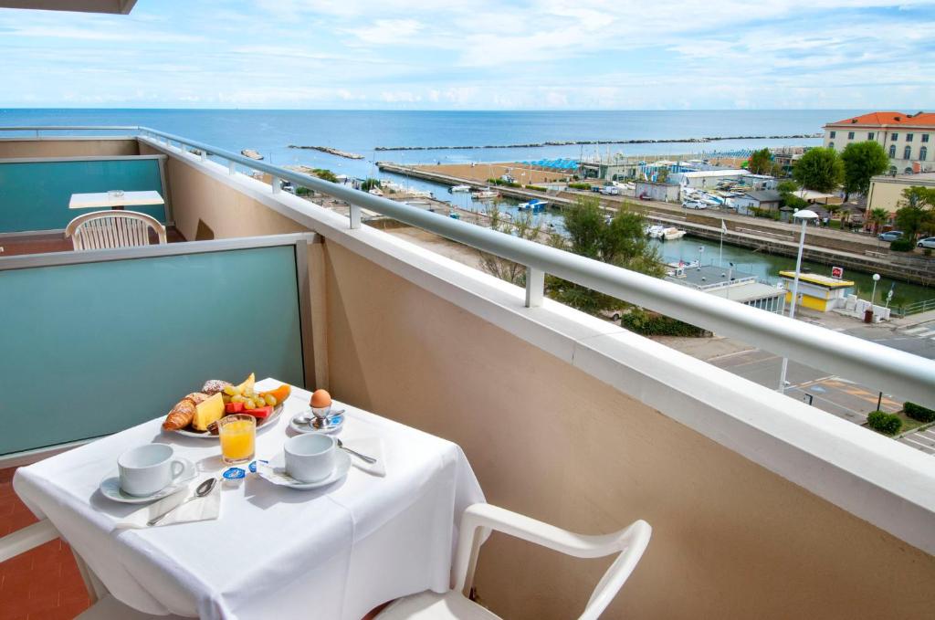 Brošūras skats uz jūru ar brokastīm uz balkona, kurā ir augļi, kruasāni un dzērienu. Ideāla vieta atpūtai un relaksācijai.