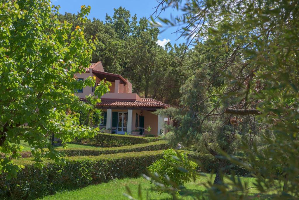 Mājīga villa ar zaļo dārzu un apkārtējiem kokiem, ideāla atpūtai dabā. Apburoša ainava ar sulīgu zāli un sakoptu apstādījumu.