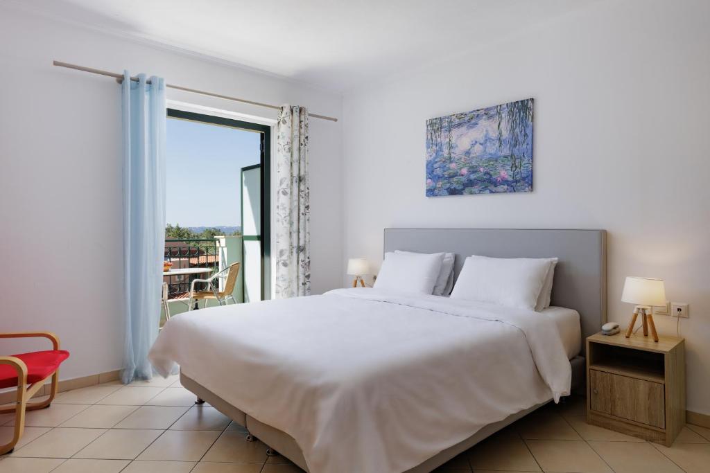 Mūsdienīgs guļamistabas interjers ar lielu divguļamo gultu, blakus logam ar skatu uz terasi un mākslas darbu uz sienas. Gaismas un minimālisma stils rada relaksējošu atmosfēru.