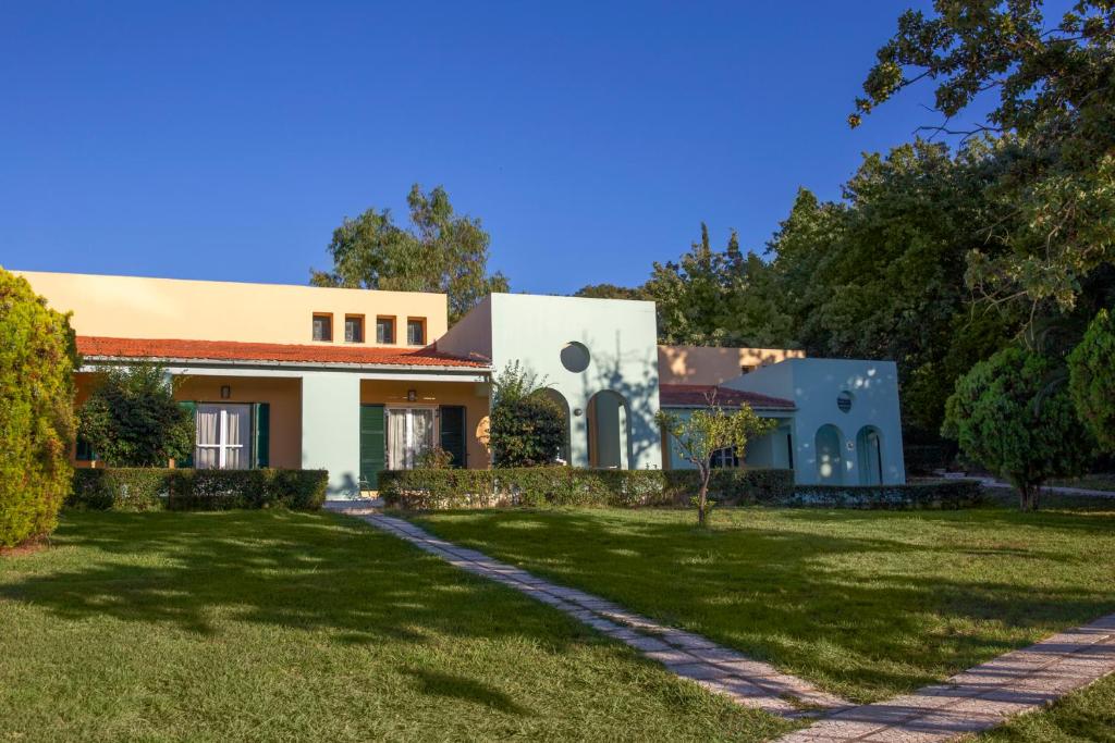 Mūsdienīga ēka ar krāsainu fasādi, ko ieskauj zaļa zāle un koki, sniedz mierīgu un pievilcīgu atmosfēru. Pastaigu celiņš ved uz mājas ieeju.