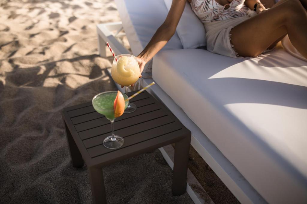 Tropu kokteiļi atpūtas zonā pludmalē, ar smiltīm un saulainu laiku. Svaigā gaisa un relaksācijas sajūta.