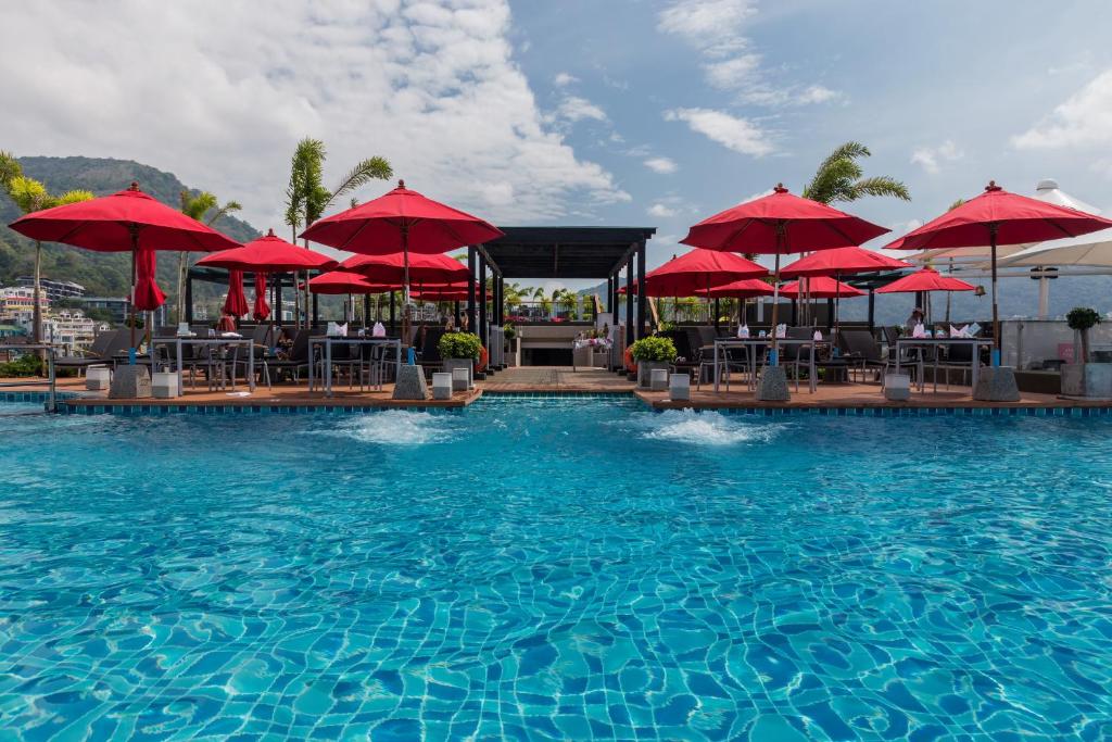 Peldbaseins ar sarkanām lietussargiem un elegantu terasi, kas sniedz brīnišķīgu skatu uz apkārtni. Ideāla vieta relaksācijai un atpūtai.