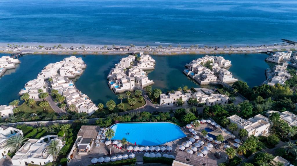 Skats uz The Cove Rotana Resort piekrastē ar baseinu un villām.