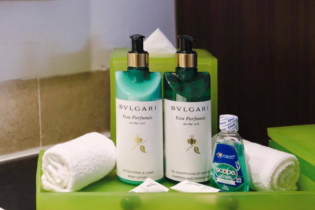 Izsmalcinātu vannas istabas piederumu komplekts ar Bvlgari zīmola ķermeņa losjonu un šampūnu, kopā ar zobu skalošanas līdzekli un dvieli.