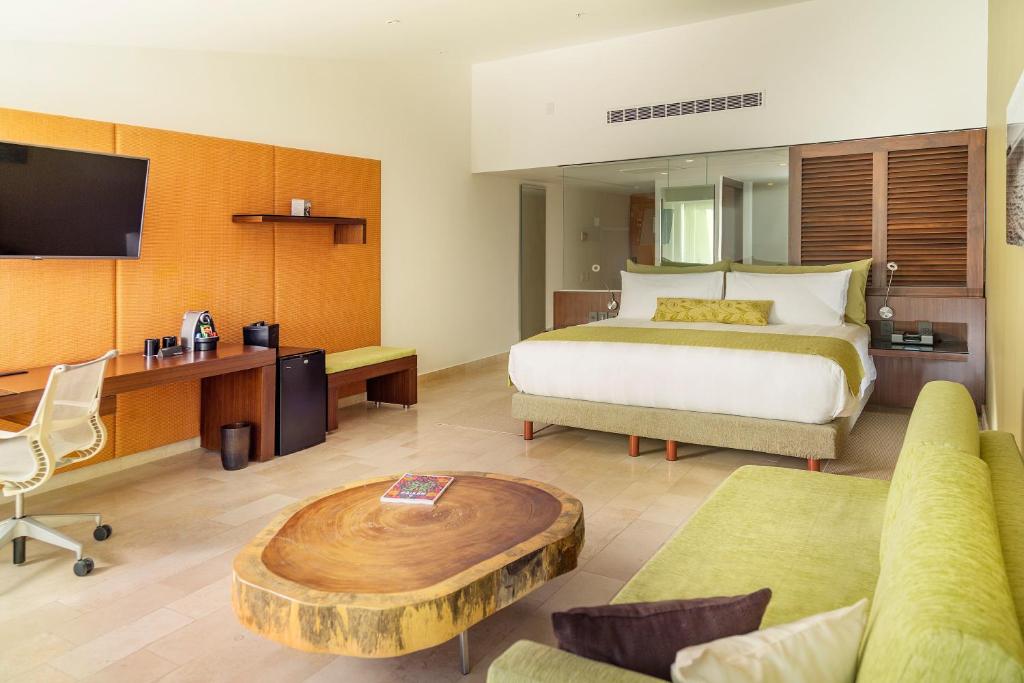 Mūsdienīgs viesnīcas numurs ar ērtu gultu un mūsdienīgu interjeru, kas ietver koka galdu un dīvānu. Numurā ir televizors un darba stacija, radot patīkamu atmosfēru atpūtai un darbam.