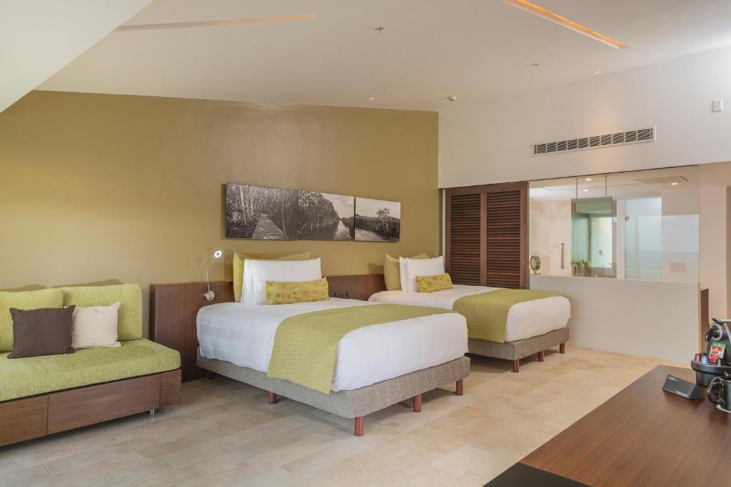 Mūsdienīgs viesnīcas numurs ar divām gultām, gaišām krāsām un dabiskiem elementiem, kas rada relaksējošu atmosfēru. Numurā ir arī dīvāns un stikla sienas, kas nodrošina gaišu un plašu telpu.