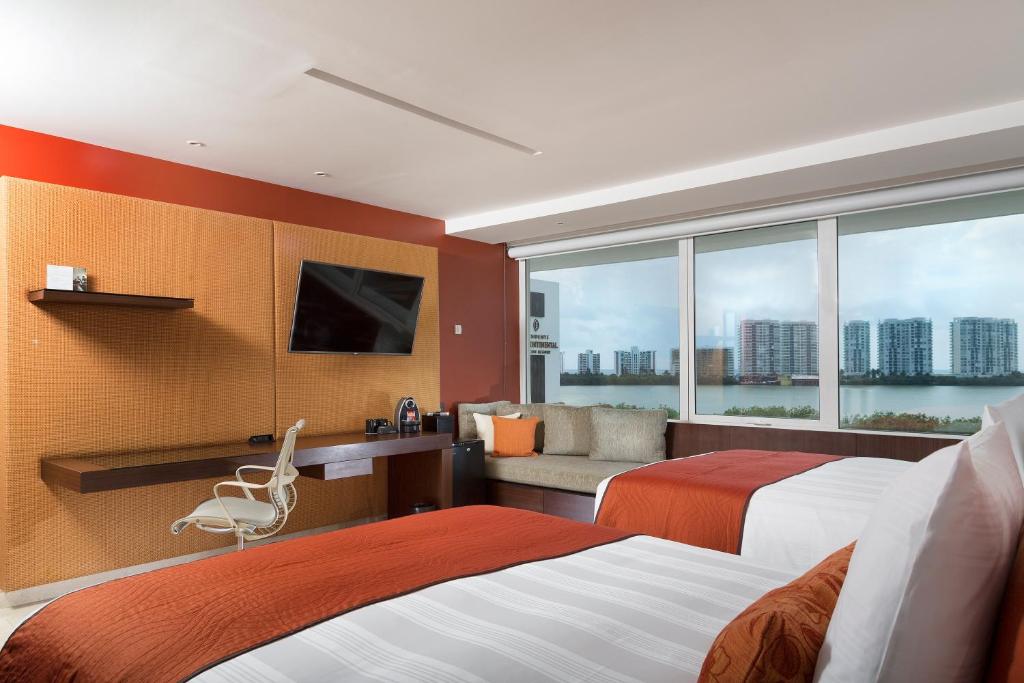 Mūsdienīgs viesnīcas numurs ar divām gultām un lielu logu, no kura paveras skats uz pilsētas ainavu. Interjera dizains ir stilīgs ar siltām krāsām un mūsdienīgām mēbelēm.