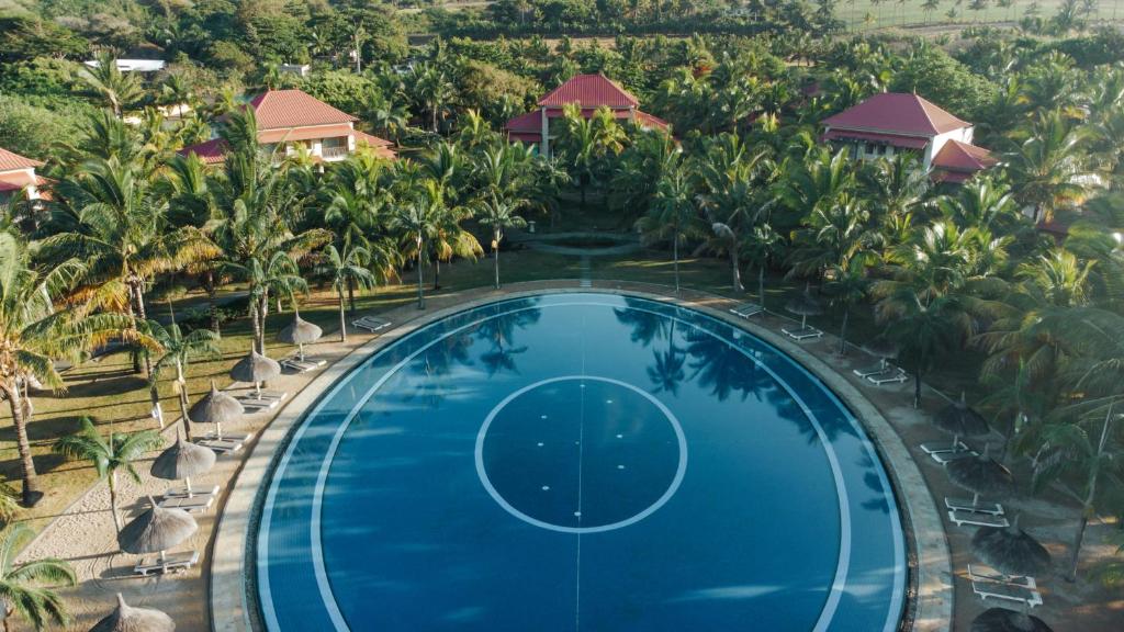 Tamassa Bel Ombre viesnīcas peldbaseins ar palmām apkārt.