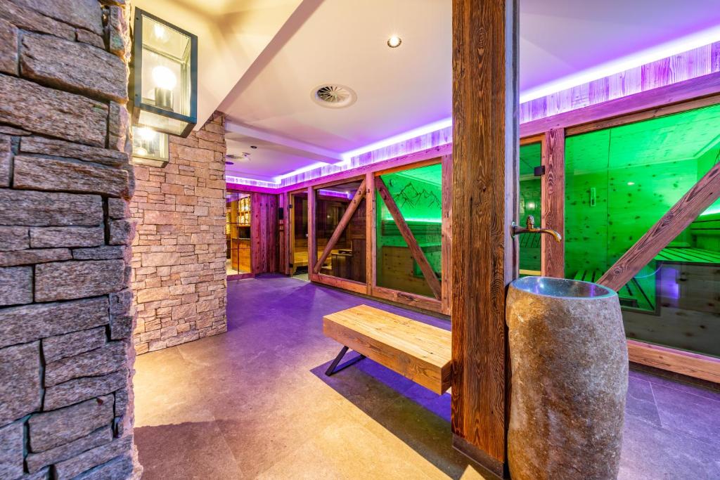 Mūsdienīgs interjers ar akmens un koka elementiem, kas apgaismots ar krāsainām gaismām, radot relaksējošu atmosfēru. Ideāla vieta atpūtai un relaksācijai.