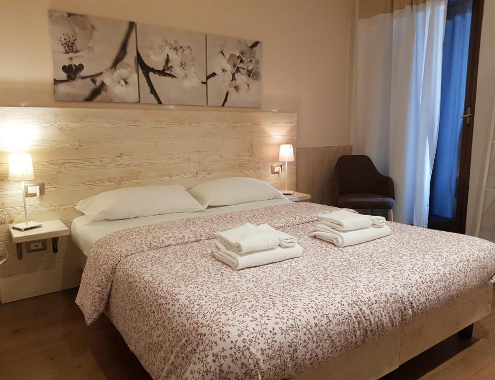 Mūsdienīgs guļamistabas interjers ar divguļamo gultu, rotātu ar ziedu rakstu, un mīkstiem spilveniem. Telpā ir gaismas avoti un liels logs, kas nodrošina dabisko apgaismojumu.