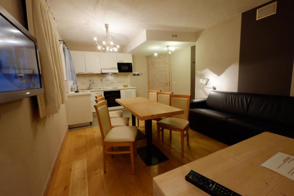 Mūsdienīga virtuve ar ēdamgaldu un ērtu dīvānu, kas radījuši mājīgu atmosfēru. Svaigi dekori un koka grīda piešķir telpai siltumu.