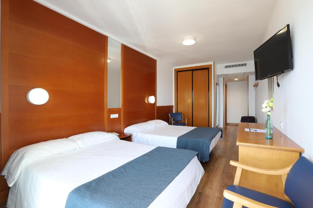 Mūsdienīgs viesnīcas numurs ar divām atsevišķām gultām, koka apdari un televizoru. Numurā ir arī galds, krēsls un zieds, radot patīkamu un viesmīlīgu atmosfēru.