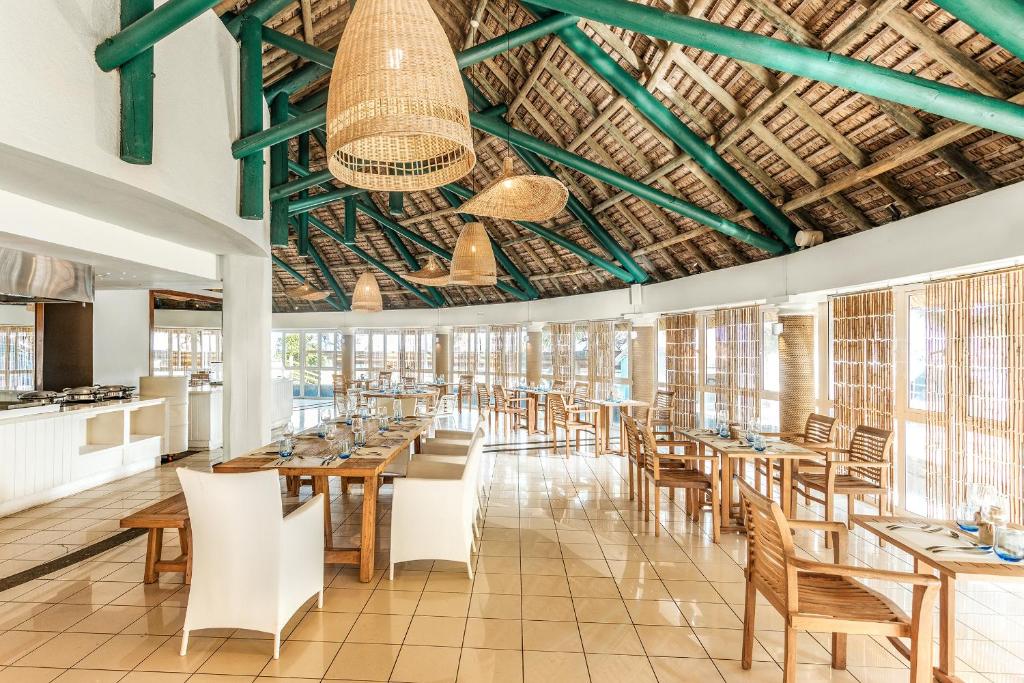 Mūsdienīgs restorāns ar atvērtu plānojumu, koka mēbelēm un dabīgiem materiāliem, kas rada siltu un viesmīlīgu atmosfēru. Gaismas ķermeņi no ratiņiem papildina interjeru, radot patīkamu noskaņu.