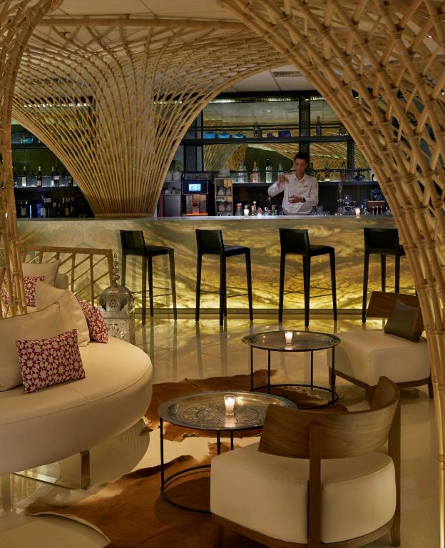 Moderns bārs ar elegantu interjeru, kurā ir izstrādātas koka un metāla detaļas, un bārmenis, kas gatavo dzērienus. Mīksti krēsli un galdi ar svecēm veido patīkamu atmosfēru.