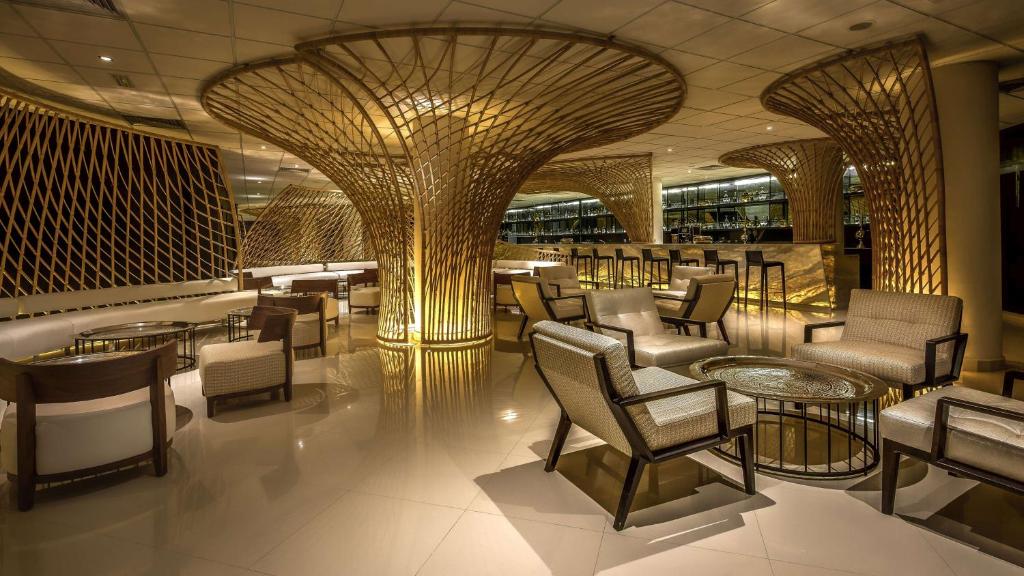 Moderns restorāns ar elegantiem koka akcentiem un mīkstām krēsliem, apgaismots ar siltu gaismu. Interjers piedāvā relaksējošu atmosfēru un stilīgu dizainu.