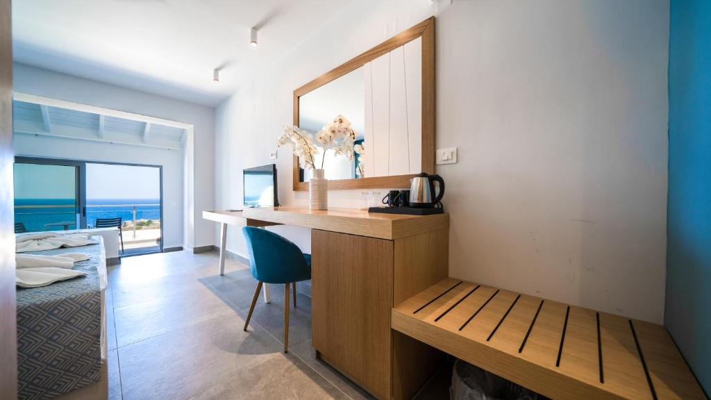 Gaišs Panorama Village Hotel numurs ar koka mēbelēm un skatu uz jūru